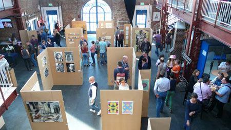 Blick von oben auf die Kunstmesse: Leute schauen sich die ausgestellten Werke an Foto: KUBOSHOW