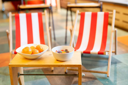 In der PACT-Werkstadt stehen zwei Strandstühle und davor auf einem Tisch Gummibärchen und Mandarinen Foto: Dirk Rose