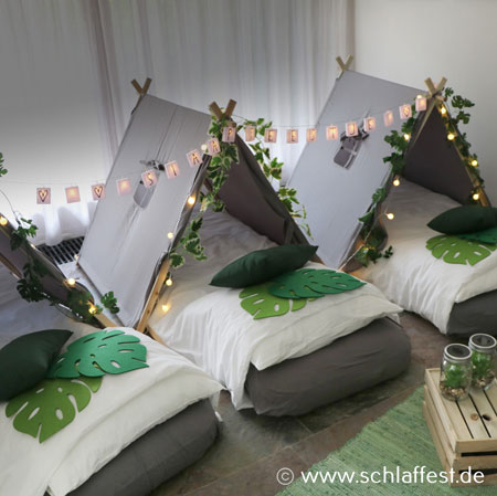 Betten unter kleinen Zelten mit grüner Dekoration, Foto: www.schlaffest.de