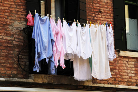 Vor einem Fenster hängt bunte und helle Wäsche zum Trocknen Foto: pixabay/Peggy_Marco