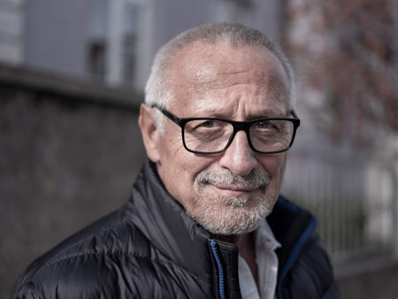 Alter Mann mit Brille und grauen Haaren trägt eine schwarze Jacke und Schal, Foto: Thomas Karsten