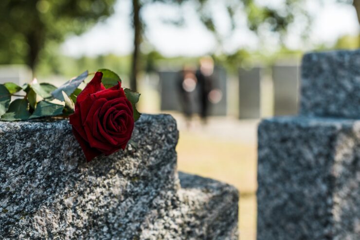 Wie man eine Bestattung organisiert. Eine Rose liegt auf einem Grabstein, (Bild: Lightfield Studios-Adobe Stock)